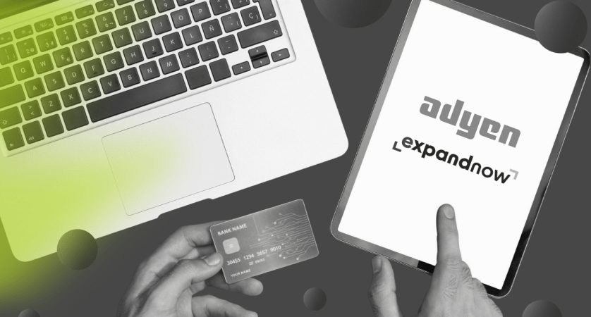 Adyen and ExpandNow logos on a tablet beside a laptop and a payment card